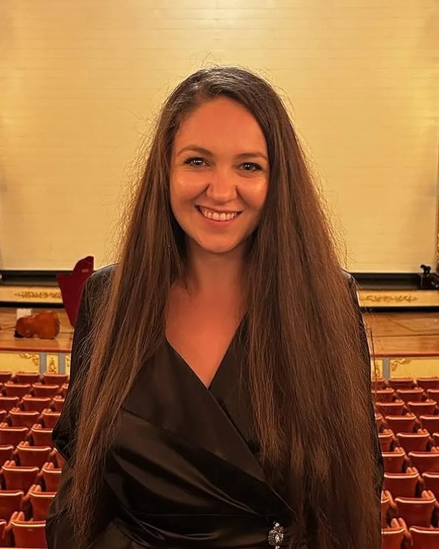 Ligia Ciornei, smiling, in a theater auditorium with red seats behind her.